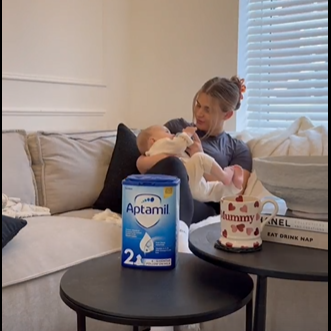 mom holding baby on couch