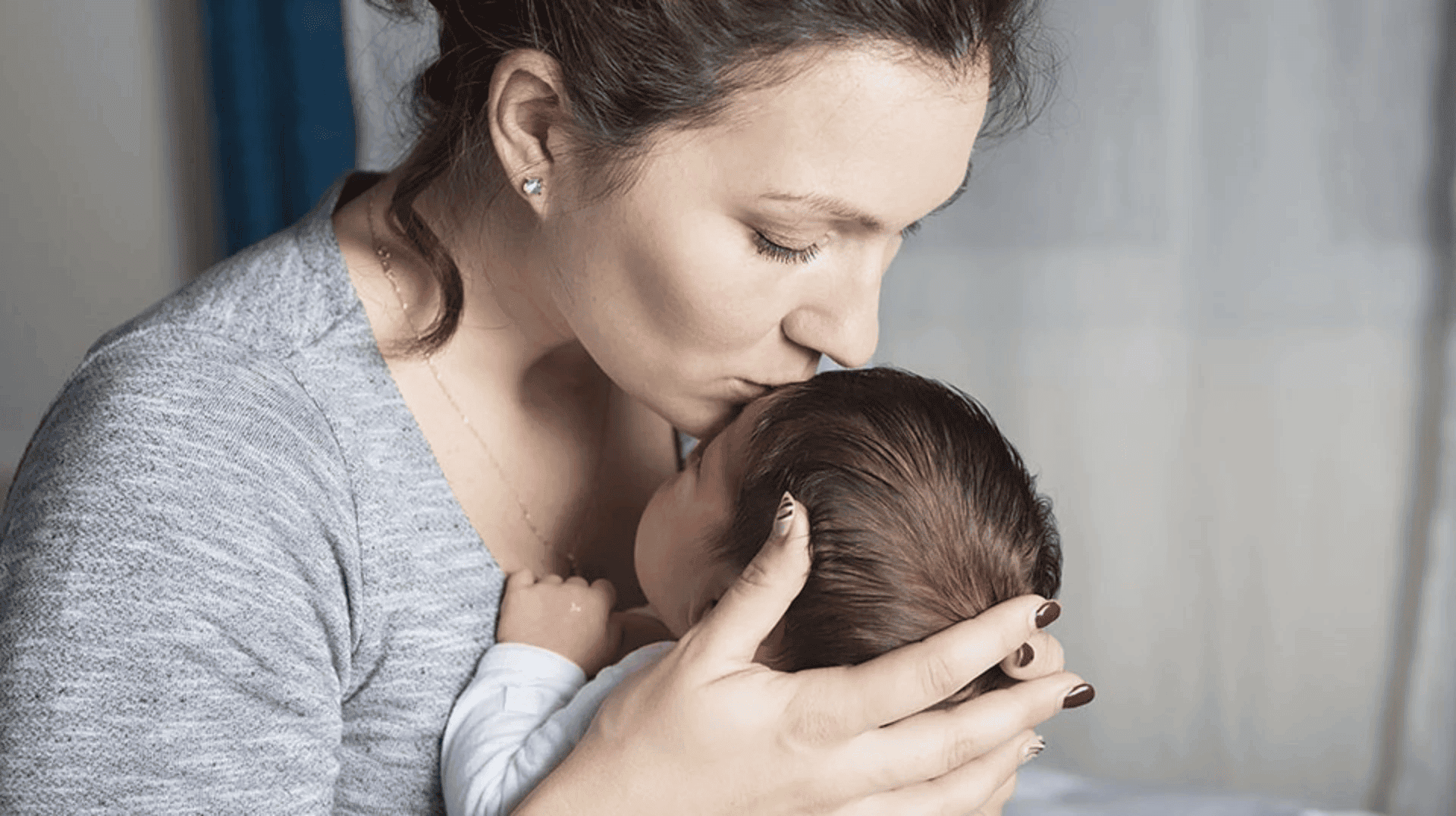 mum kissing new born